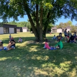 Children eating lunch under a tree